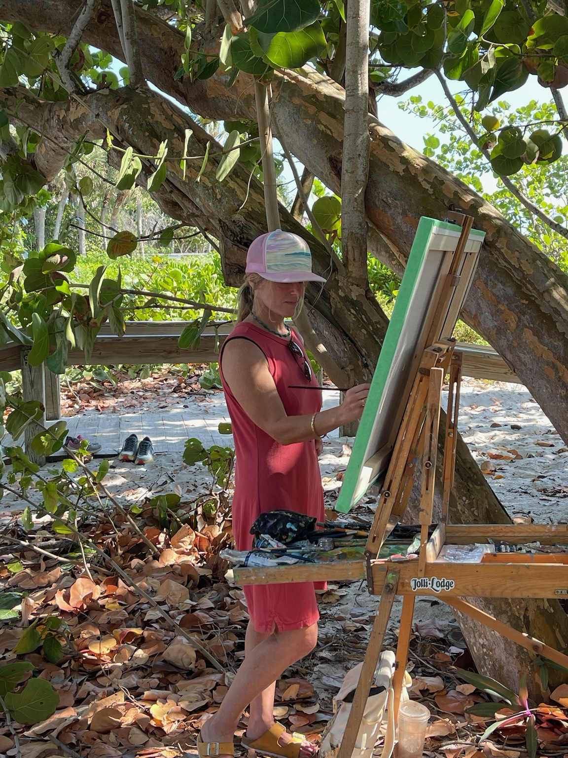 Larissa Flynn painting outdoors beneath a tree